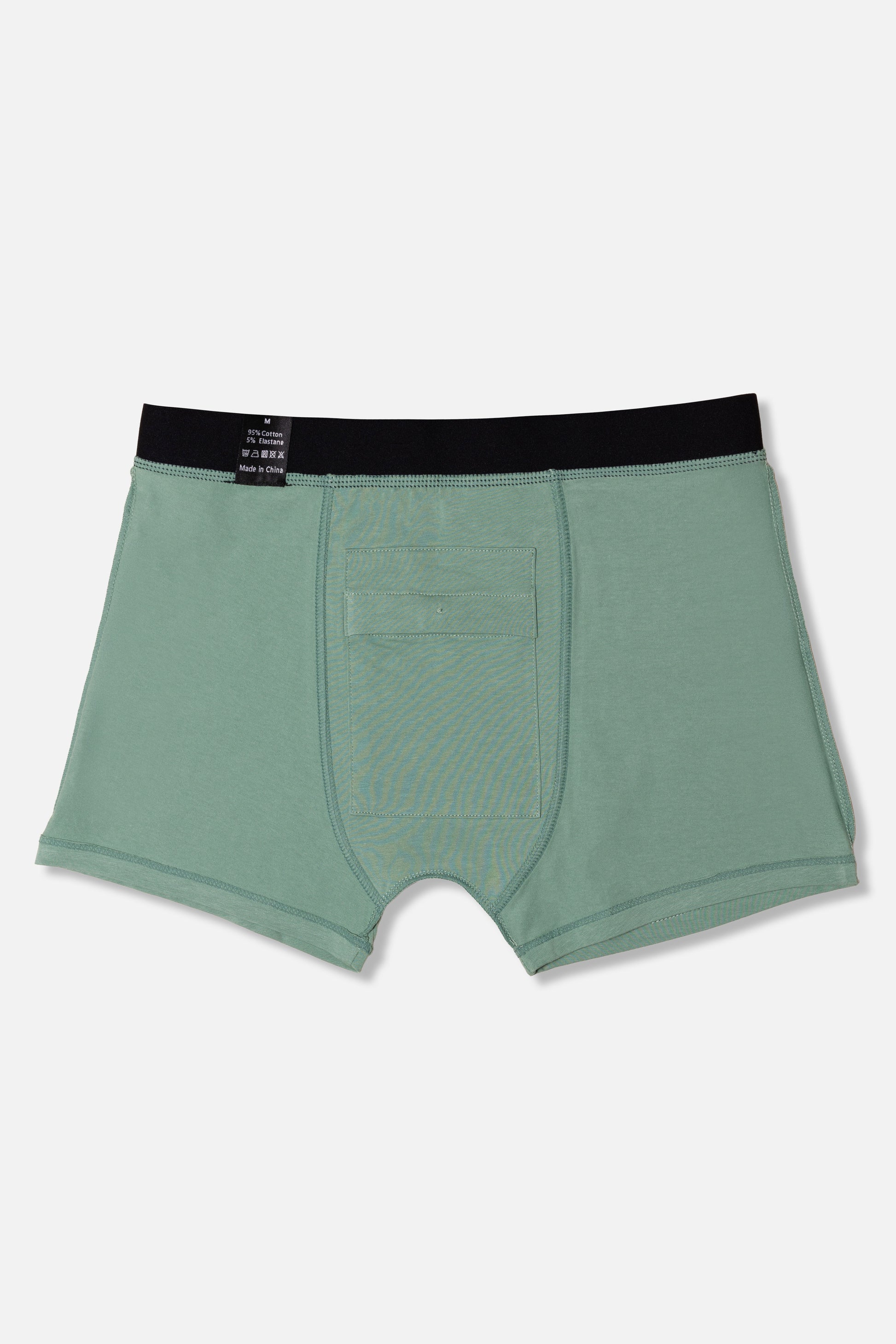 Inside the front of the green boxer briefs with black waistband on a light gray background