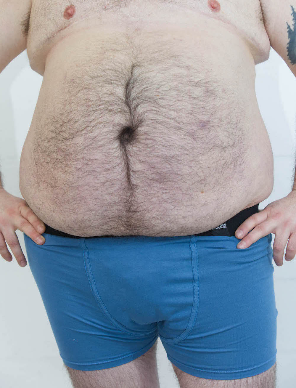 Person wearing size L blue packing boxer brief with soft-form packer in front of a white background
