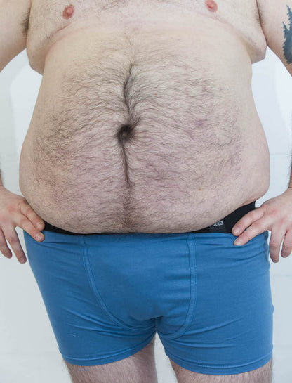 Person wearing size L blue packing boxer brief with soft-form packer in front of a white background