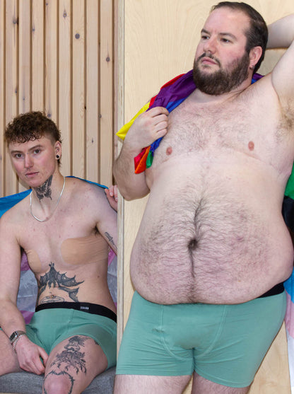 Models wearing green packing boxers with trans pride and LGBTQIA+ pride flags as accessories. Left model wears size M. Right model wears size L.