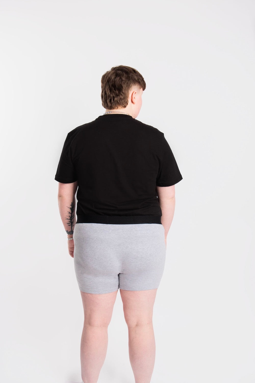 Back of a person wearing size L grey packing boxers and black t-shirt.