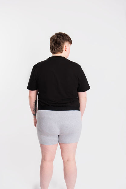 Back of a person wearing size L grey packing boxers and black t-shirt.
